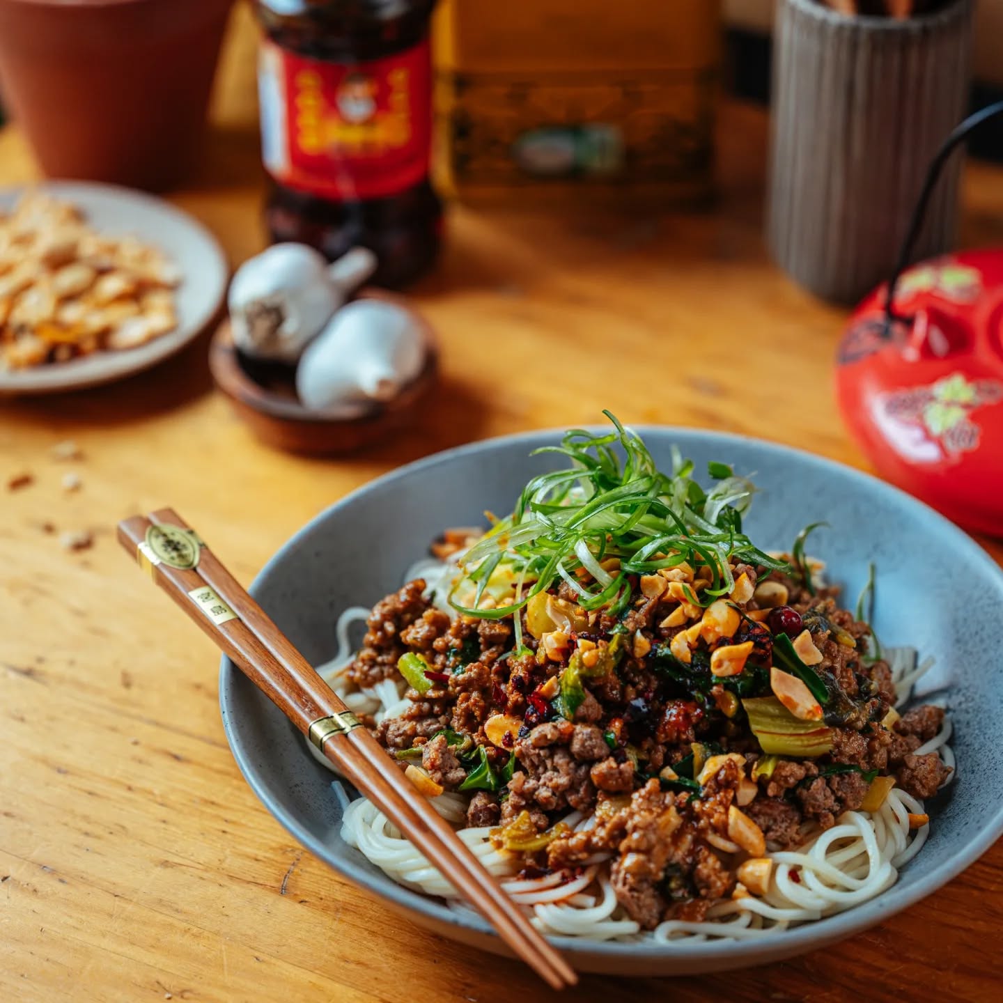 Dan dan noodles topped with peanuts and scallions